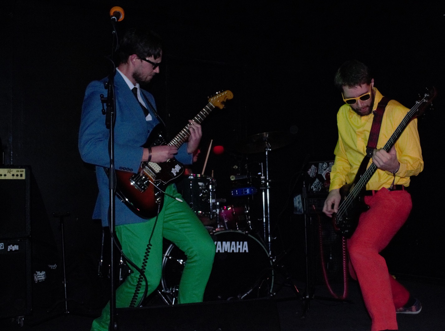 Two guys in brightly colored clothes playing their guitars