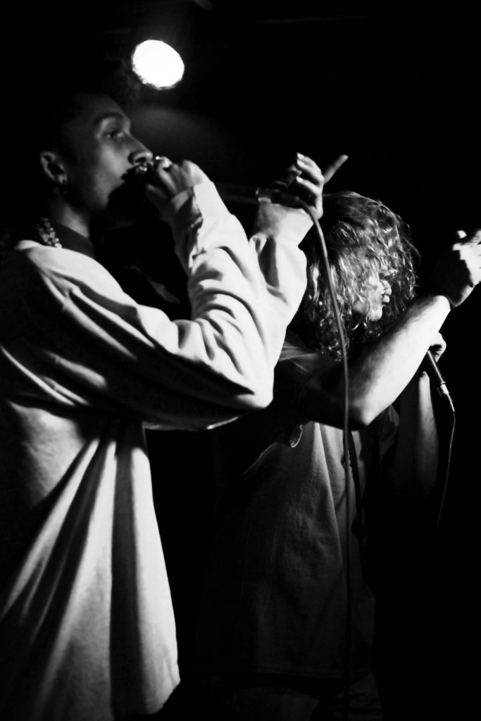 two males singing in black and white