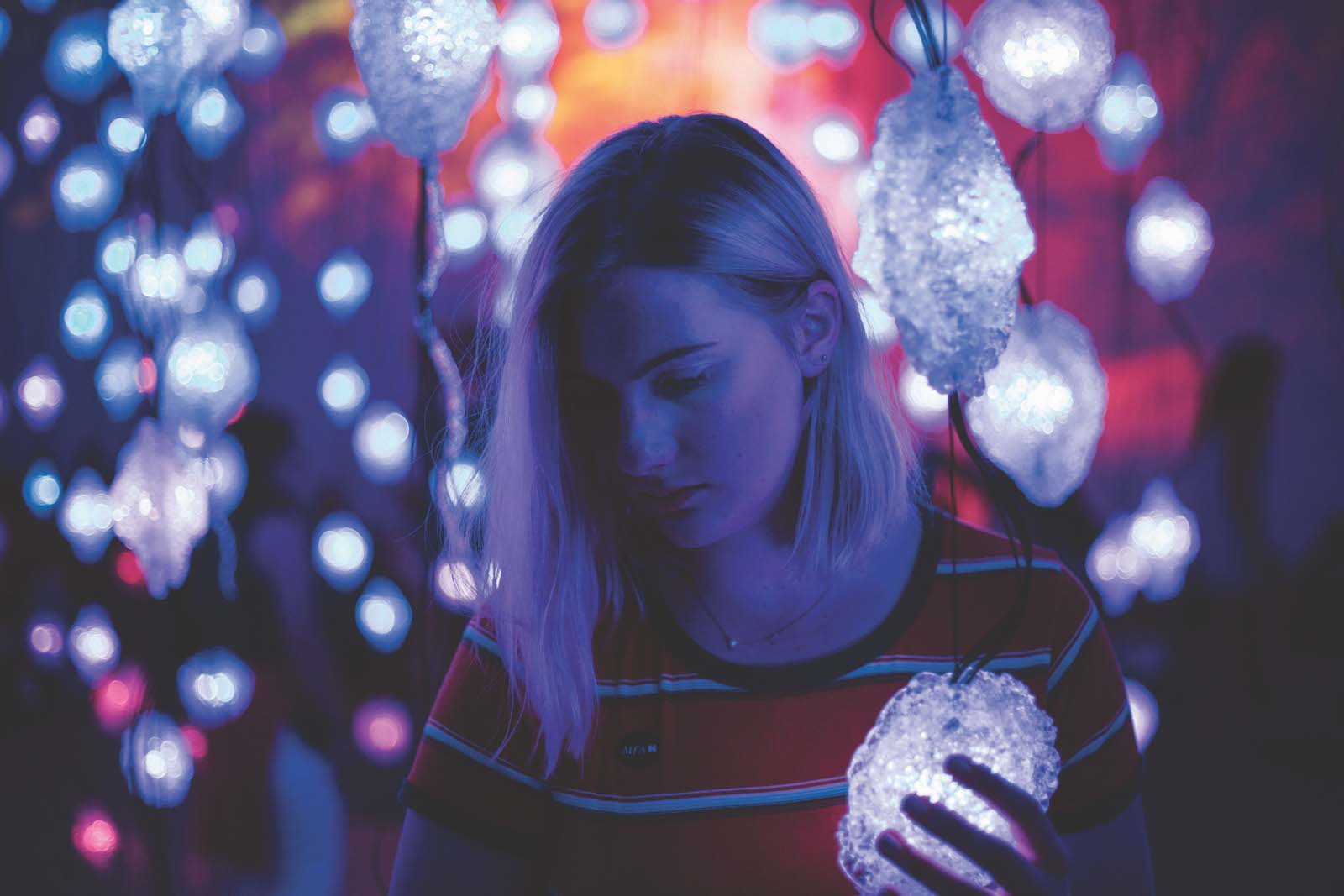 woman going through strings of lights